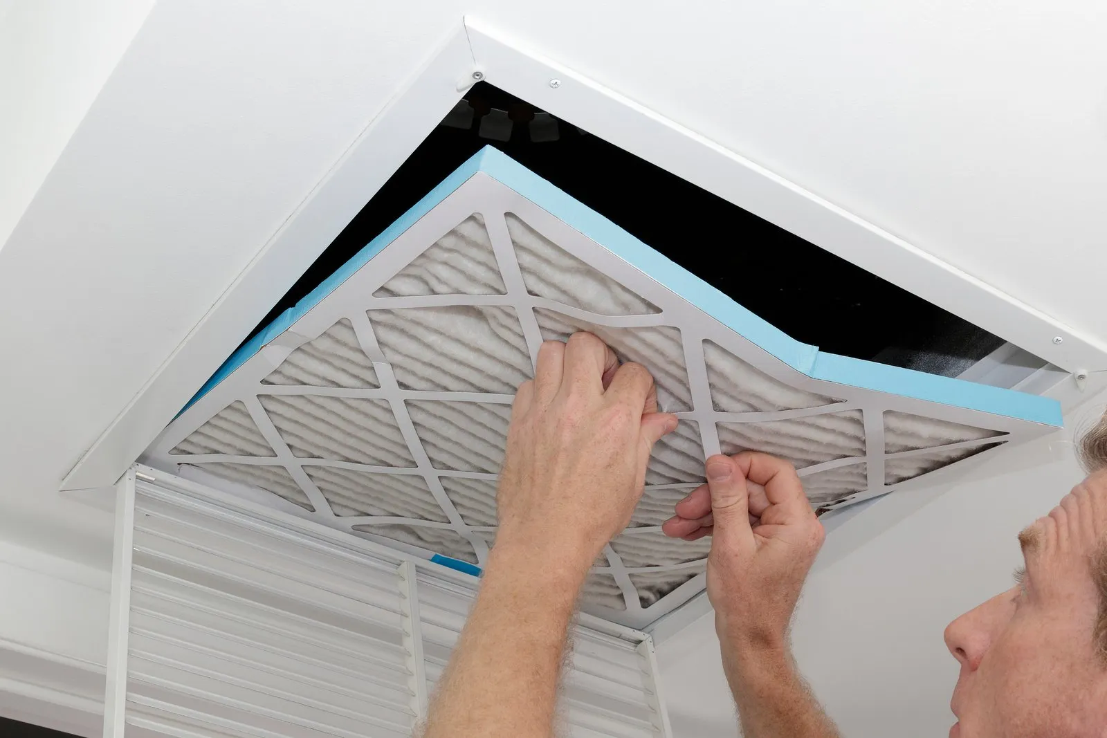 Technician cleaning an air duct vent in a St. Augustine home